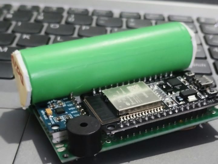 SurakshaMesh bench node: ESP32 board with a cylindrical battery pack and buzzer during bring-up.